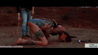 Ass eating bondage slave cries while her feet get caned outdoors in the dirt